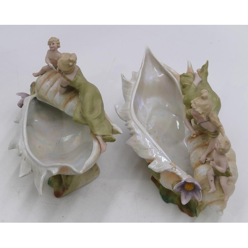 121 - A pair of Bisque china vases in form of shells with lady and cupid motifs, on white and green ground... 