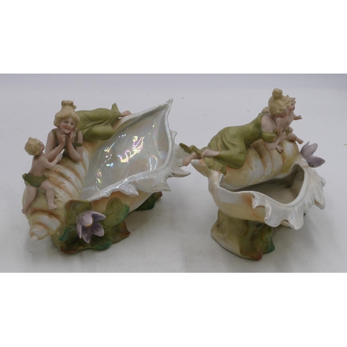 121 - A pair of Bisque china vases in form of shells with lady and cupid motifs, on white and green ground... 