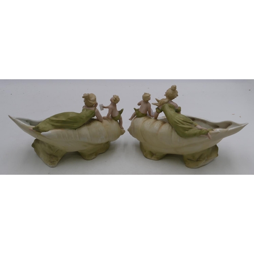 121 - A pair of Bisque china vases in form of shells with lady and cupid motifs, on white and green ground... 