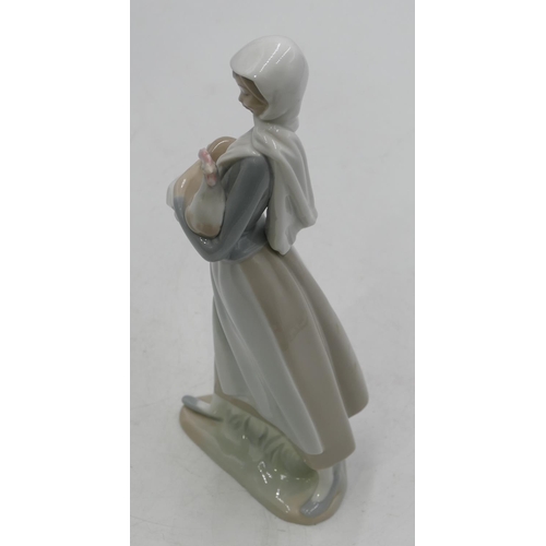 130 - A Lladro figure of a standing lady holding a hen and a basket, 25cm high.