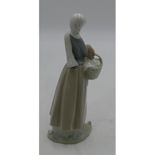 130 - A Lladro figure of a standing lady holding a hen and a basket, 25cm high.