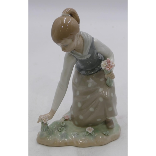 131 - A Lladro figure of a kneeling girl picking flowers, 21.5cm high.