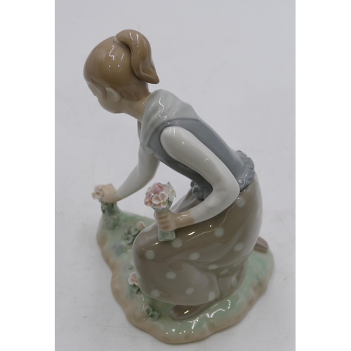 131 - A Lladro figure of a kneeling girl picking flowers, 21.5cm high.