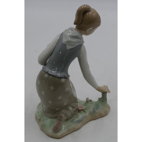 131 - A Lladro figure of a kneeling girl picking flowers, 21.5cm high.