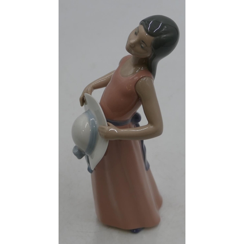 132 - A Lladro figure of a young girl in pink dress holding a bonnet, 25cm high.