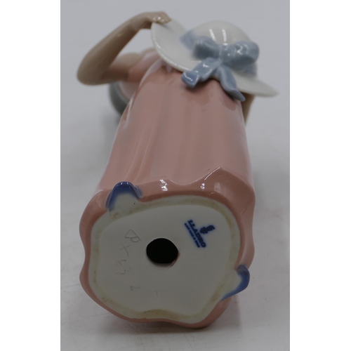 132 - A Lladro figure of a young girl in pink dress holding a bonnet, 25cm high.