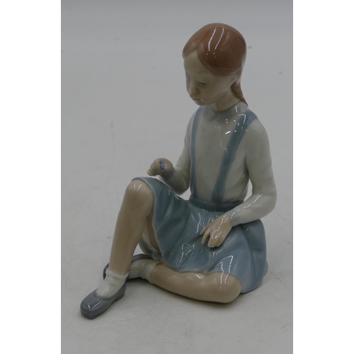 133 - A Lladro figure of a seated young girl (flowers missing), 16cm high.