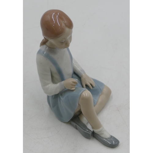 133 - A Lladro figure of a seated young girl (flowers missing), 16cm high.