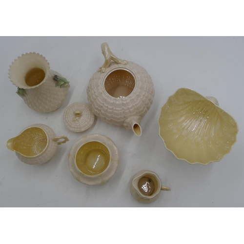 139 - A Belleek shell shaped round bulbous teapot, a similar jug, a Belleek milk jug and sugar bowl, a Bel... 