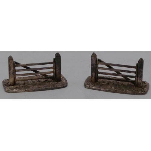 249 - A pair of silver plated knife rests in form of gates, 8cm long.