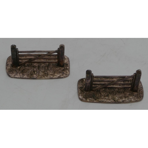 249 - A pair of silver plated knife rests in form of gates, 8cm long.