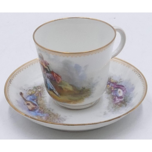26 - A Serves cup and saucer on white ground with multi-coloured figure, musical instrument and landscape... 