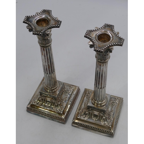 279 - A pair of Victorian silver Corinthian column candlesticks with embossed square sweeping bases, Sheff... 