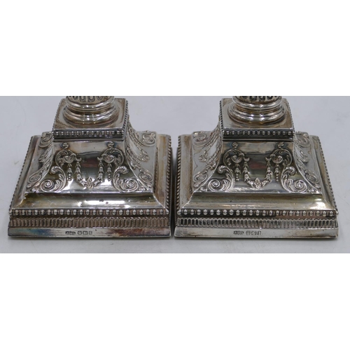 279 - A pair of Victorian silver Corinthian column candlesticks with embossed square sweeping bases, Sheff... 