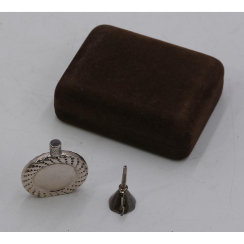 299 - A Sterling silver miniature flat scent bottle with screw lid and small funnel, cased