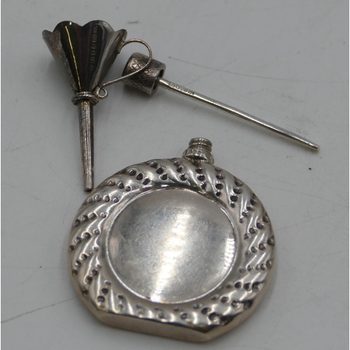 299 - A Sterling silver miniature flat scent bottle with screw lid and small funnel, cased