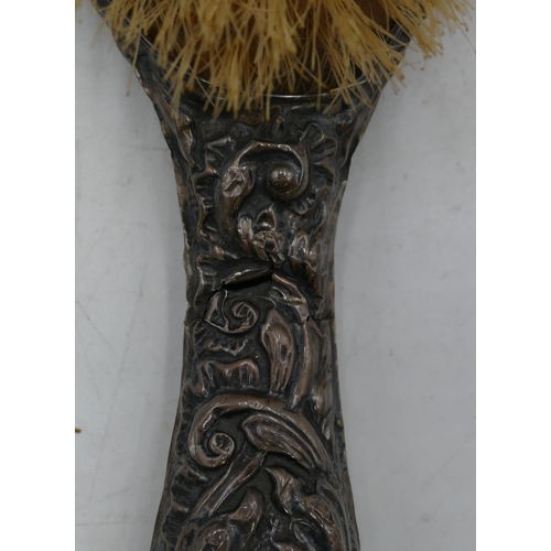 313 - A silver hand mirror and a silver mounted hair brush with embossed decoration (dented). (2).