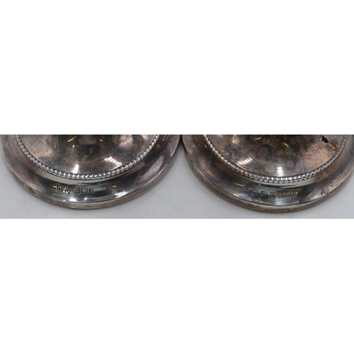 356 - A pair of Birmingham silver candlesticks on round turn stems with sweeping bases, 16cm high