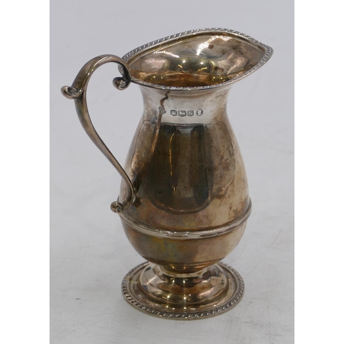 370 - A Sheffield silver round bulbous shaped milk jug with scroll handle on sweeping foot, maker William ... 