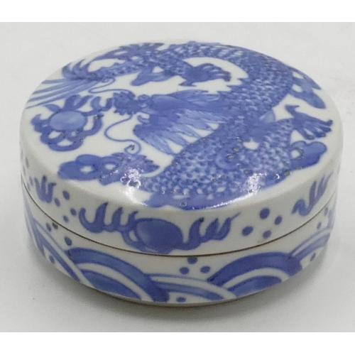 38 - An Oriental cylindrical lidded blue and white pot with dragon decoration, 10cm diameter, 4.5cm high.