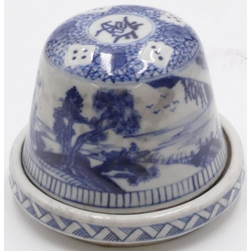 41 - An Oriental China dice pot with cover on blue and white ground on stand, landscape and dice decorati... 
