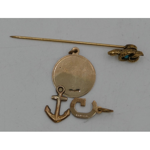 427 - A 9ct gold St Christopher and 2 9ct gold charms, a tie pin with serpent motif mounted with turquoise... 