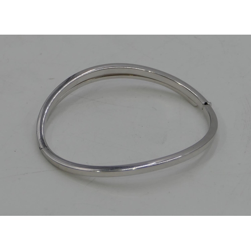 435 - A 9ct white gold hinged bangle, 7.7 grams.