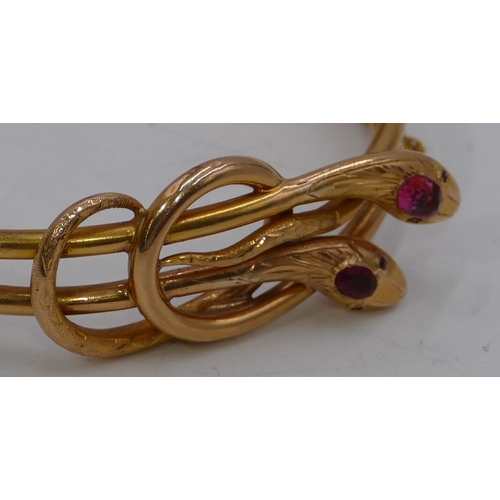 441 - A gold double row bangle with serpent motif and inset with coloured stones, 22.3 grams gross.