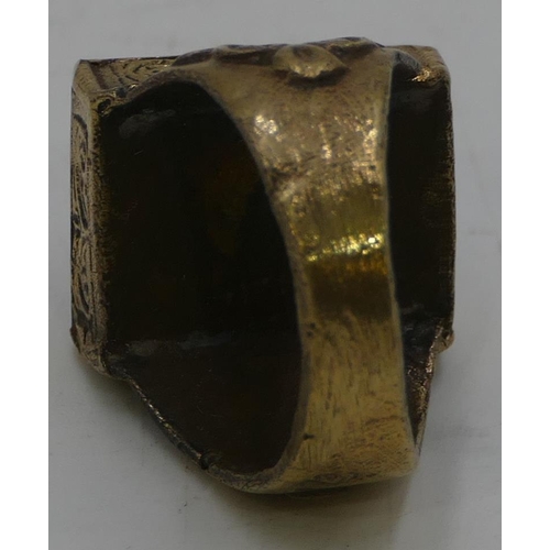 473 - A brass rectangular shaped ring set with pale green stone with engraved decoration, size T.