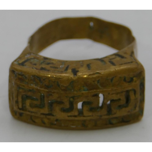 474 - A brass Roman style ring with pierced key pattern decoration, size U.