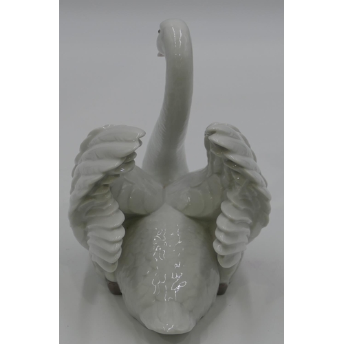 48 - A Lladro figure of a swan with raised wings, 18cm high.