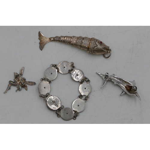 493 - A Chinese silver coloured bracelet, a silver brooch in the form of a pixie, a pendant in the form of... 