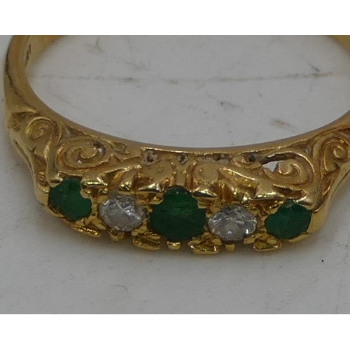 506 - An 18ct gold ladies ring set with 3 emeralds, interspersed with 2 small diamonds, size L/M, 3.2g