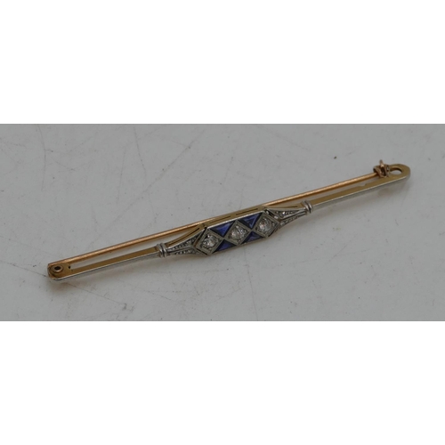 524 - A 14ct gold 2-coloured gold Art Deco style bar brooch mounted with 3 centre diamonds and 4 triangula... 