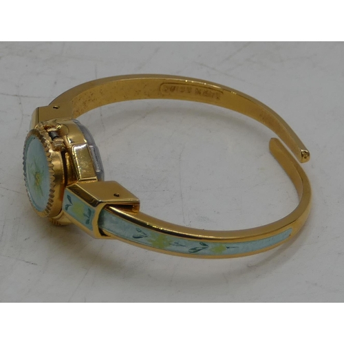 528 - An Andre Mouche gilt metal and enamelled watch with expanding strap, hinged top enclosing dial.