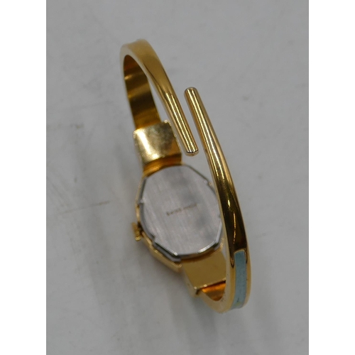 528 - An Andre Mouche gilt metal and enamelled watch with expanding strap, hinged top enclosing dial.