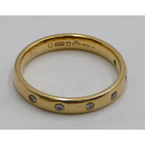 551 - An 18ct gold ladies wedding ring inset with 6 small diamonds, size L/M.  3.1g