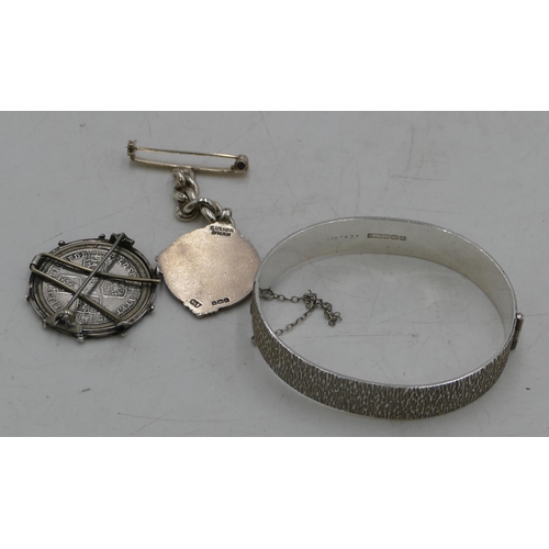 556 - A Birmingham silver hinged bangle, a silver round brooch mounted with George III coin and a silver f... 