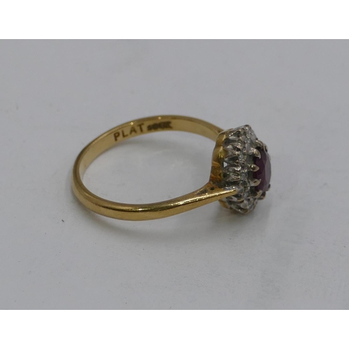 597 - A 18ct gold oval cluster ring set with centre ruby, surrounded by small diamond chips, size M, 3.3gr... 