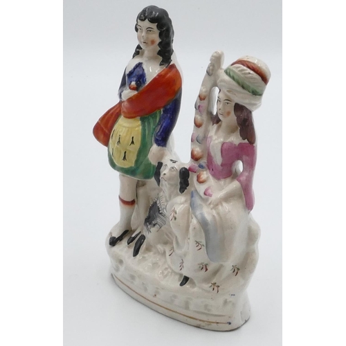 6 - A 19th Century Staffordshire group of seated lady and standing Scotsman with a dog at their feet, 21... 