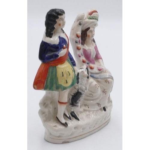 6 - A 19th Century Staffordshire group of seated lady and standing Scotsman with a dog at their feet, 21... 