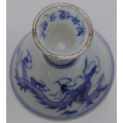 60 - An Oriental round trumpet shaped cup on blue and white ground with dragon decoration, 9cm high.