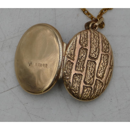 677 - A 9ct gold oval locket with chased decoration, with 9ct gold chain, 7.8 grams gross.