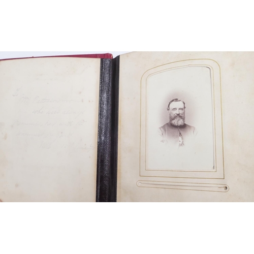 720 - A Victorian red leather photograph album with embossed and gilt decoration, featuring black and whit... 