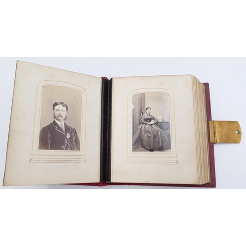 720 - A Victorian red leather photograph album with embossed and gilt decoration, featuring black and whit... 