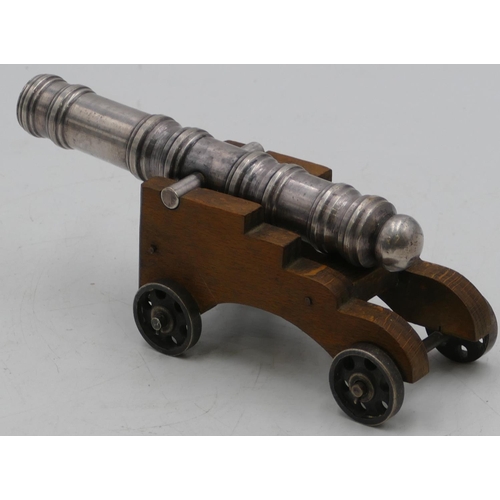 755 - A silvered metal table top cannon with wooden carriage, 19.5cm long