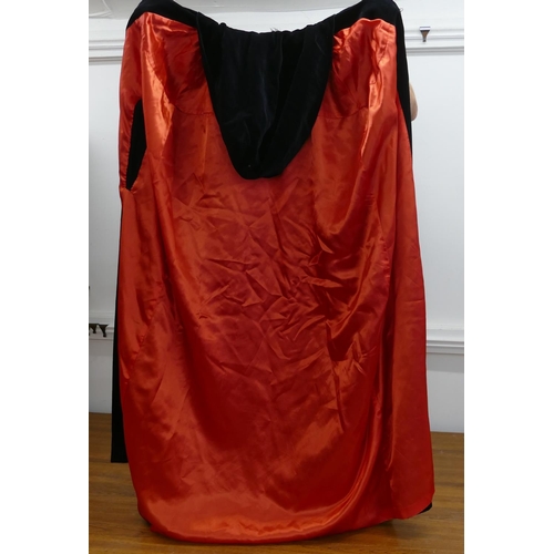 759 - A black velvet and red silk lined hooded cloak.