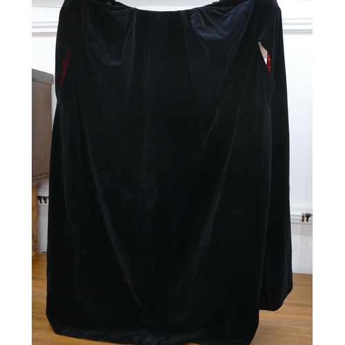 759 - A black velvet and red silk lined hooded cloak.