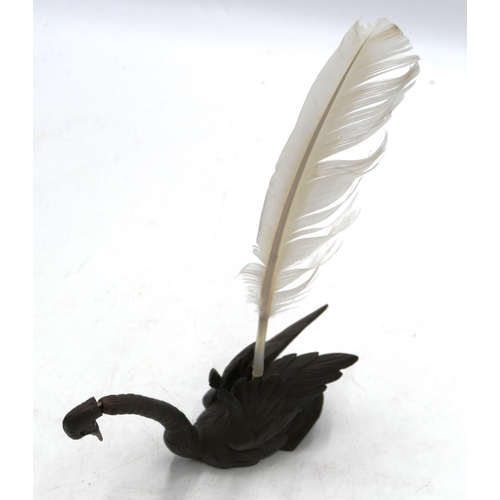 762 - A Black Forest carved pen holder in the form of a swan with articulated neck and feather quill. (2)