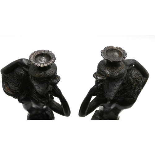 764 - A pair of bronze candlesticks in form of half-naked ladies holding urns above their heads, on round ... 